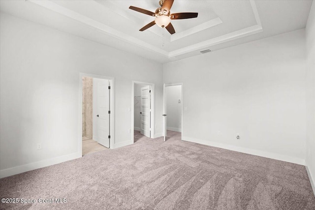 998 Wacona St SE, Palm Bay, FL 32909 - unfurnished bedroom with carpet flooring, a raised ceiling, a walk in closet, and baseboards