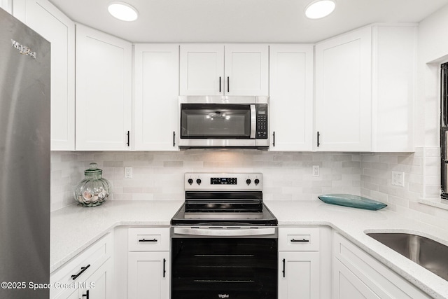 113 Harbor Dr, Cape Canaveral, FL 32920 - kitchen with stainless steel appliances, white cabinets, backsplash, and recessed lighting