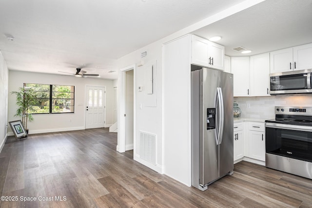 113 Harbor Dr, Cape Canaveral, FL 32920 - kitchen featuring stainless steel appliances, dark wood-style flooring, white cabinets, a ceiling fan, and tasteful backsplash