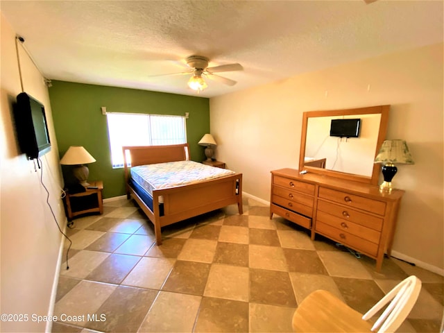 bedroom featuring a textured ceiling, baseboards, and ceiling fan
