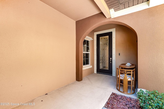 doorway to property featuring stucco siding