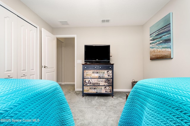 carpeted bedroom featuring a closet and baseboards
