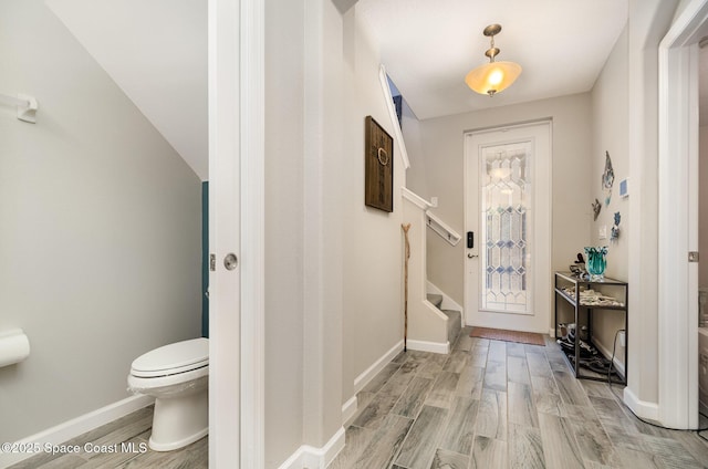 entrance foyer with stairway, light wood-style flooring, and baseboards
