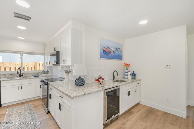 225 Price Ct, Satellite Beach, FL 32937 - kitchen with beverage cooler, stainless steel appliances, a sink, backsplash, and recessed lighting