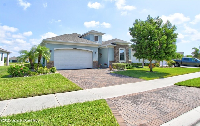 2242 Great Belt Cir, Melbourne, FL 32940 - view of front facade featuring stone siding, decorative driveway, an attached garage, stucco siding, and a front yard