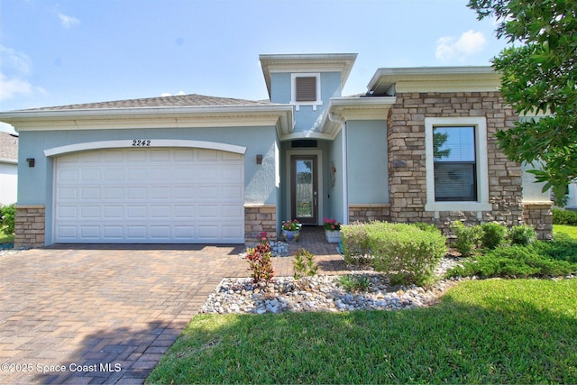 2242 Great Belt Cir, Melbourne, FL 32940 - view of front of house featuring stucco siding, decorative driveway, stone siding, and an attached garage