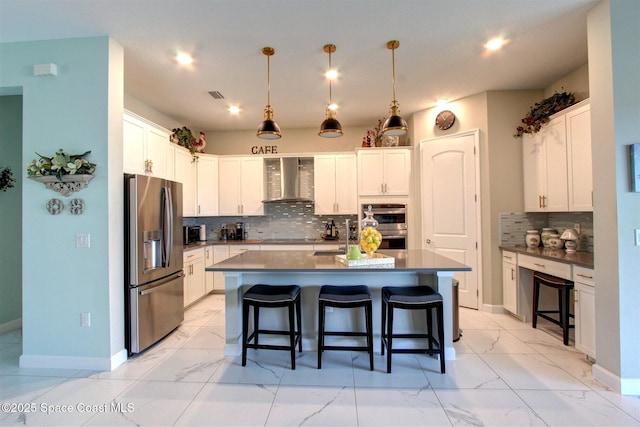 2242 Great Belt Cir, Melbourne, FL 32940 - kitchen featuring stainless steel appliances, wall chimney range hood, a kitchen bar, light marble finish flooring, and baseboards