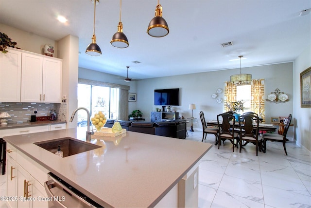 2242 Great Belt Cir, Melbourne, FL 32940 - kitchen featuring a sink, dishwasher, pendant lighting, tasteful backsplash, and white cabinets