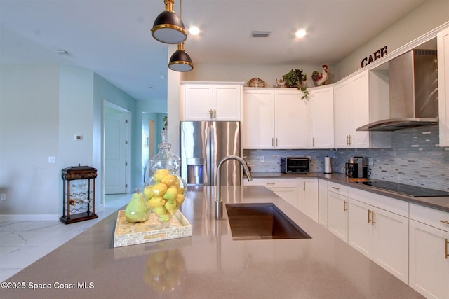 2242 Great Belt Cir, Melbourne, FL 32940 - kitchen featuring stainless steel fridge, wall chimney range hood, a sink, black electric cooktop, and tasteful backsplash