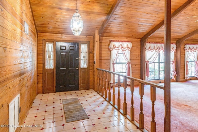 foyer entrance featuring wooden ceiling, wood walls, and light flooring