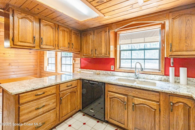 kitchen featuring dishwasher, a sink, brown cabinetry, and plenty of natural light