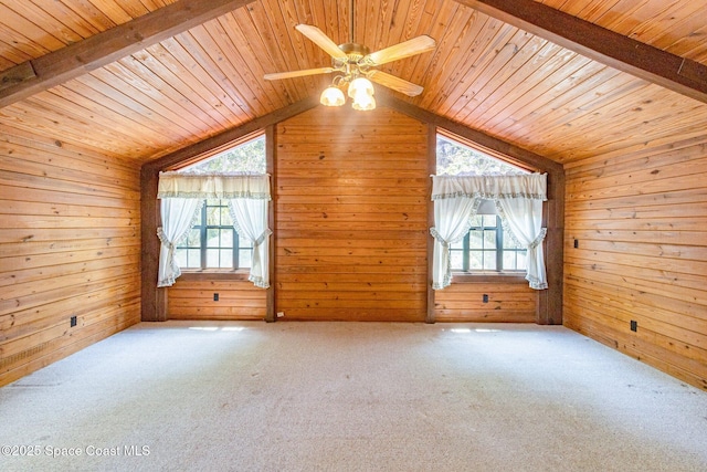 additional living space with wooden ceiling, plenty of natural light, wood walls, carpet, and a ceiling fan