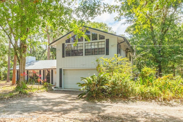 view of front of house featuring an attached garage and dirt driveway