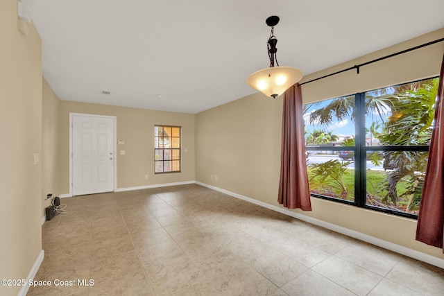 spare room with light tile patterned flooring and baseboards