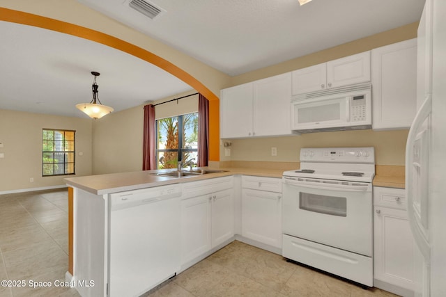 kitchen with white appliances, a sink, a peninsula, and light tile patterned floors