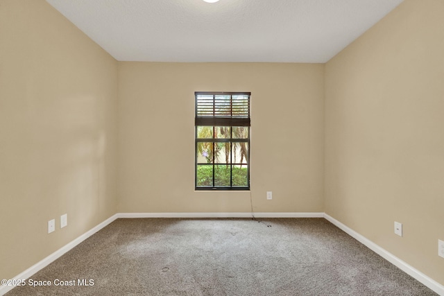 carpeted spare room with baseboards