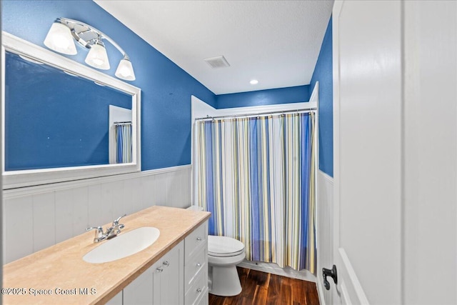 6345 Anchor Ln, Rockledge, FL 32955 - full bathroom with wainscoting, vanity, wood finished floors, toilet, and a shower with curtain