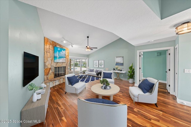 6345 Anchor Ln, Rockledge, FL 32955 - living area with wood finished floors, vaulted ceiling, a fireplace, a textured ceiling, and a ceiling fan