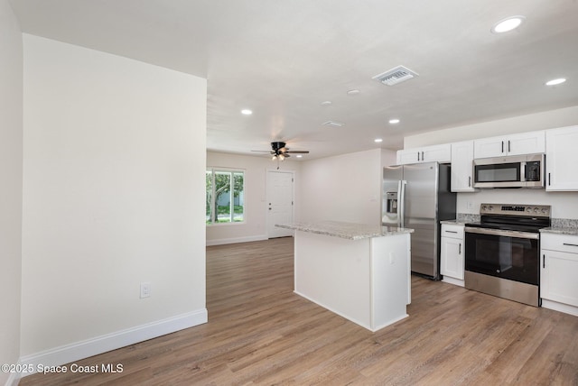 878 Iroquois Ave, Melbourne, FL 32935 - kitchen featuring stainless steel appliances, recessed lighting, a kitchen island, baseboards, and white cabinetry
