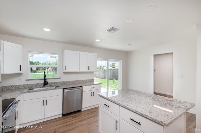 878 Iroquois Ave, Melbourne, FL 32935 - kitchen with appliances with stainless steel finishes, a sink, light wood-type flooring, light stone counters, and white cabinets