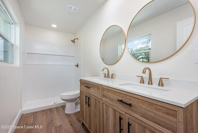 878 Iroquois Ave, Melbourne, FL 32935 - full bath featuring toilet, wood finished floors, double vanity, a tile shower, and recessed lighting
