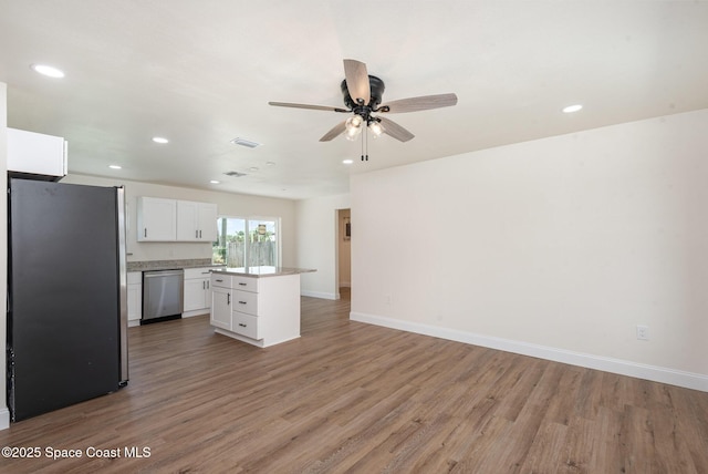 878 Iroquois Ave, Melbourne, FL 32935 - kitchen featuring appliances with stainless steel finishes, white cabinets, a kitchen island, light wood-style flooring, and ceiling fan