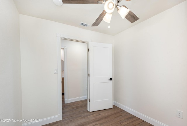 878 Iroquois Ave, Melbourne, FL 32935 - unfurnished bedroom with wood finished floors, baseboards, and a ceiling fan