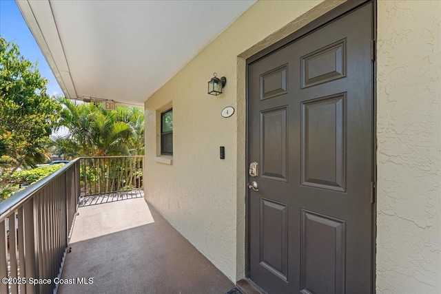 entrance to property featuring stucco siding and a balcony