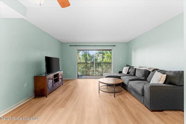 living area with light wood-style floors, baseboards, and a ceiling fan