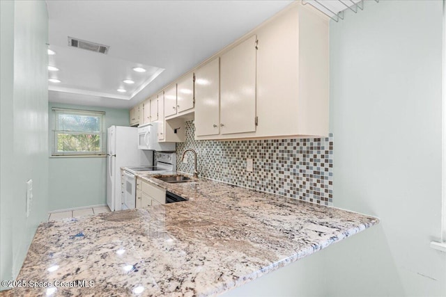 kitchen with white appliances, a sink, tasteful backsplash, cream cabinets, and recessed lighting