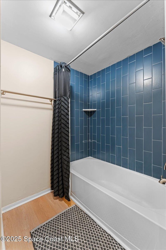 full bath with shower / bathtub combination with curtain, wood finished floors, and baseboards