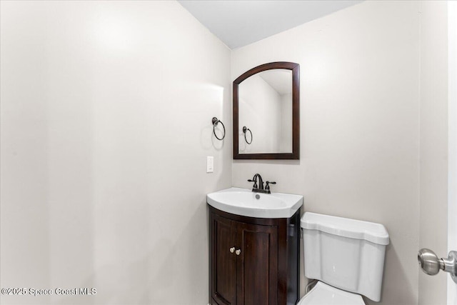 half bathroom with vanity and toilet