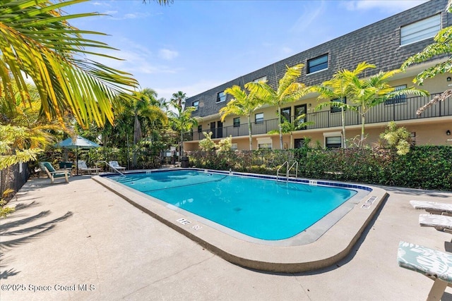 community pool featuring fence and a patio area