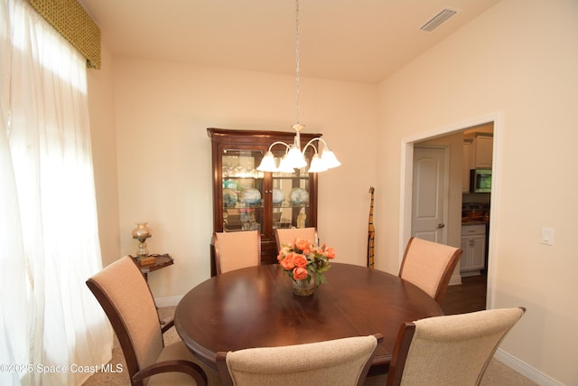 dining area with a chandelier and baseboards
