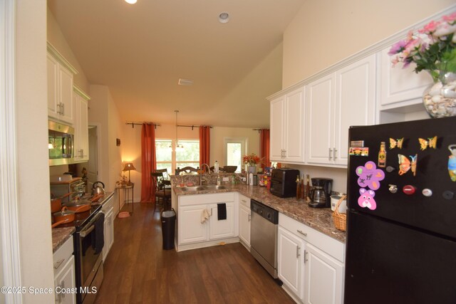 kitchen featuring stainless steel appliances, a sink, a peninsula, white cabinetry, and dark wood-style flooring
