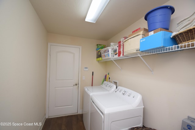 clothes washing area with independent washer and dryer, dark wood-type flooring, and baseboards