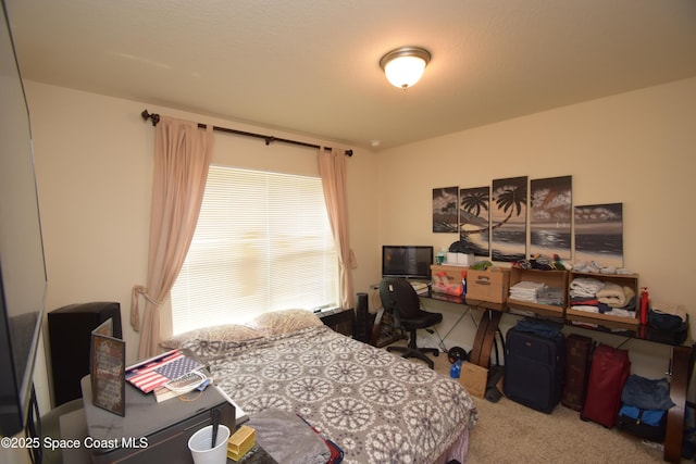 carpeted bedroom with a desk