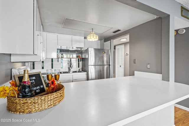 55 Riverside Dr Unit 103, Cocoa, FL 32922 - kitchen with freestanding refrigerator, white cabinetry, a sink, and light countertops