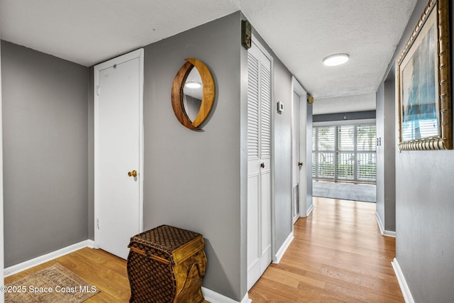 55 Riverside Dr Unit 103, Cocoa, FL 32922 - corridor with light wood-style floors, baseboards, and a textured ceiling