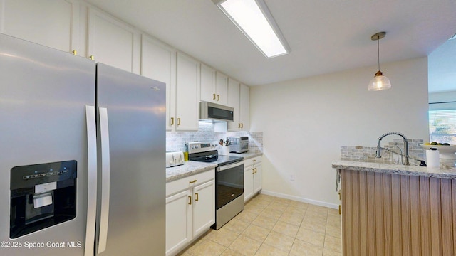 4047 Meander Pl Unit 205, Rockledge, FL 32955 - kitchen with appliances with stainless steel finishes, backsplash, white cabinets, and light tile patterned floors