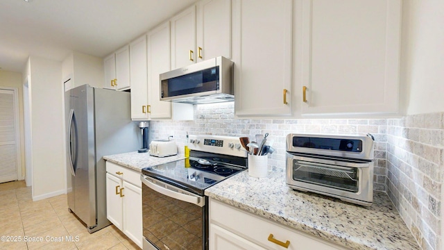 4047 Meander Pl Unit 205, Rockledge, FL 32955 - kitchen featuring appliances with stainless steel finishes, light stone counters, and white cabinetry
