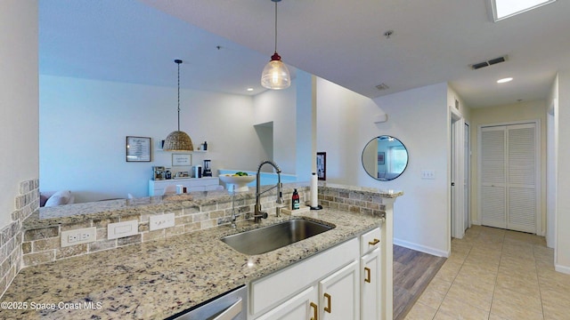 4047 Meander Pl Unit 205, Rockledge, FL 32955 - kitchen with a sink, baseboards, white cabinets, light stone countertops, and pendant lighting