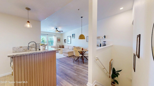 4047 Meander Pl Unit 205, Rockledge, FL 32955 - kitchen with light stone counters, a ceiling fan, decorative light fixtures, light wood-style flooring, and open floor plan
