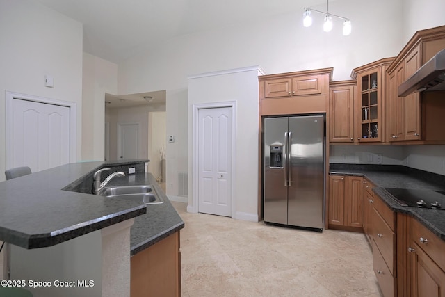 127 Lancha Cir Unit 204, Satellite Beach, FL 32937 - kitchen featuring stainless steel fridge with ice dispenser, black electric cooktop, dark countertops, a sink, and brown cabinets