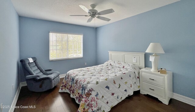 bedroom with baseboards, dark wood-type flooring, and ceiling fan