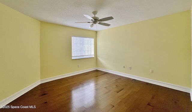 empty room with dark wood-style flooring, a ceiling fan, baseboards, and a textured ceiling