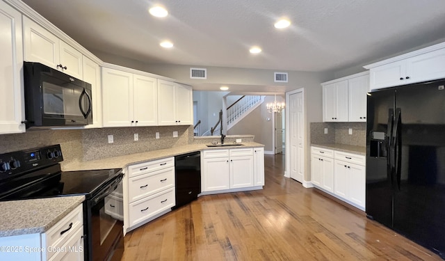 kitchen with black appliances, tasteful backsplash, recessed lighting, and white cabinetry