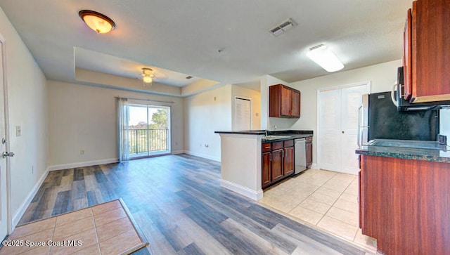 kitchen featuring dishwasher, light wood-type flooring, open floor plan, and baseboards