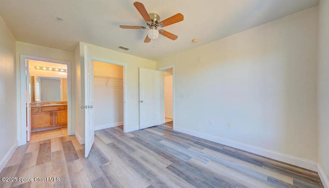 unfurnished bedroom with light wood-style floors, baseboards, and a closet