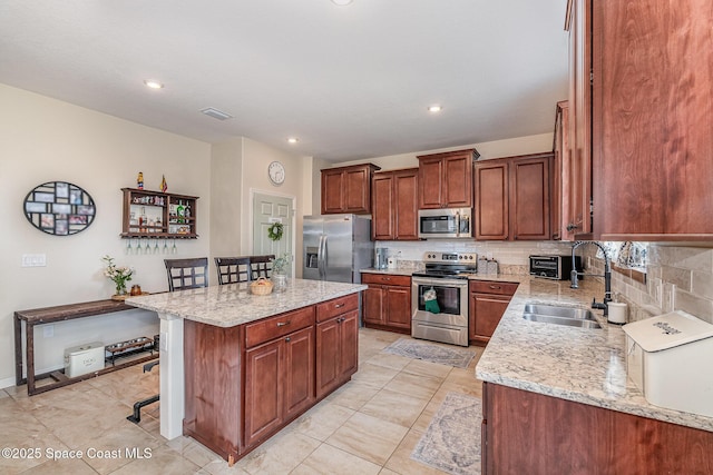 4109 Alligator Flag Cir, West Melbourne, FL 32904 - kitchen featuring appliances with stainless steel finishes, a sink, a kitchen breakfast bar, backsplash, and a center island